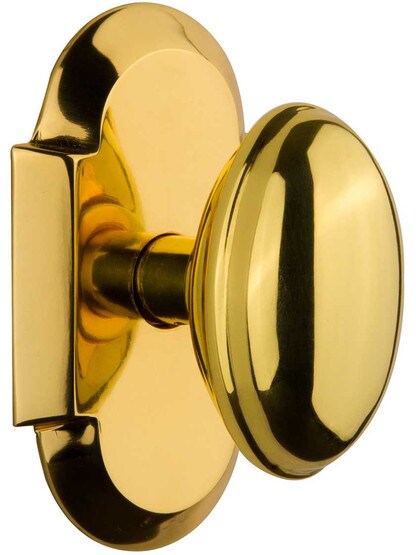 Arched Rosette Door Set with Homestead Knobs in Polished Brass.